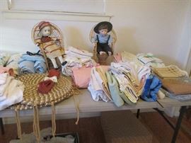 Seated Pair of Dolls, surrounded by washcloths and cloth napkins