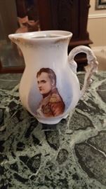 19th Century Authentic porcelain creamer/milk server with hand painted portrait of Napoleon Bonaparte made by Victoria-Carlsbad in Austria with refined painting and golden borders. 
This extremely rare and hard to find Bohemian antique porcelain creamer/milk server has a hand painted portrait of Napoleon on the front with his uniform.... this server is missing the lid and has lost some of the gold glaze but is in great condition for its age.     
