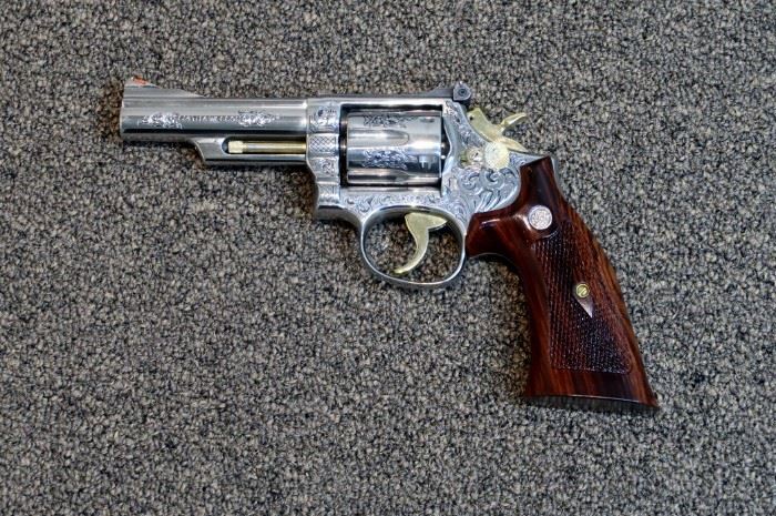 LOT # 21 - SMITH & WESSON MODEL 66-1 STAINLESS STEEL REVOLVER AUCTION ESTIMATE $2,700.00 - $3,200.00 CALIBER .357 MAG., CUSTOM ENGRAVED BY THE LATE GARY RICHARDS OF GR ENGRAVING IN SAN ANTONIO, TEXAS. VERY DEEP ENGRAVING WITH BLACK HIGHLIGHTS. THIS IS AN EARLY MODEL 66 AND IT'S ABSOLUTELY GORGEOUS AND THE GUN IS NEW