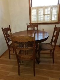 Antique, oak table (with 2 leaves) and chairs. More  cane seat chairs available too.