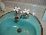 Three turquoise blue sinks with faucets