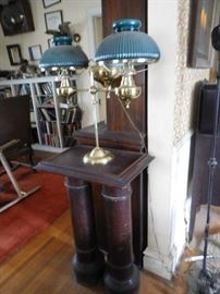 green  lamp  on  a   double  pedestal ,lots  of  books 