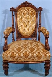 161a Walnut Victorian arm parlor chair with carved back and black and gold upholstery, 40 in. T, 24 in. W, 22 in. D.