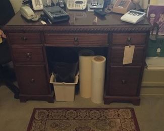 Small office desk,Assorted telephones, cassette player,rug,Trashcan, Rolls paper.