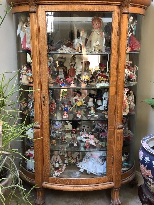 Antique china cabinet filled with dolls from around the world