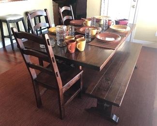 Rustic trestle style farmhouse  dining table with bench seating, and three matching dining chairs