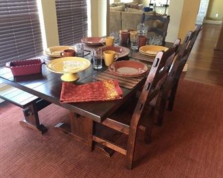 Rustic trestle style farmhouse  dining table with bench seating, and three matching dining chairs
