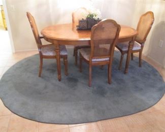Dining Room Table/4-Chairs by Thomasville with 2-16" Leaves, 44" X 66". Chairs have Cane Backs and Upholstered Seats. Oval Blue Area Rug, 7' X 9'