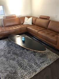 Leather sectional Sofa in Camel surfboard Eames style table grey shag rug