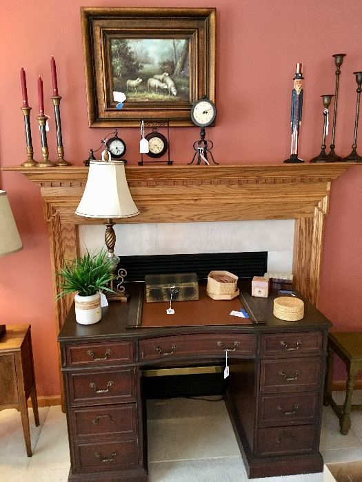 Kneehole desk; table lamp; clocks, candlesticks; framed art of sheep