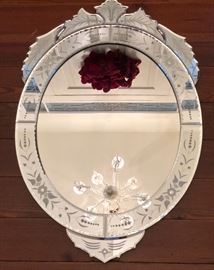 Venetian style foliate glass wall mirror. Reversed etched, floriform crest over applied beveled embellishments.