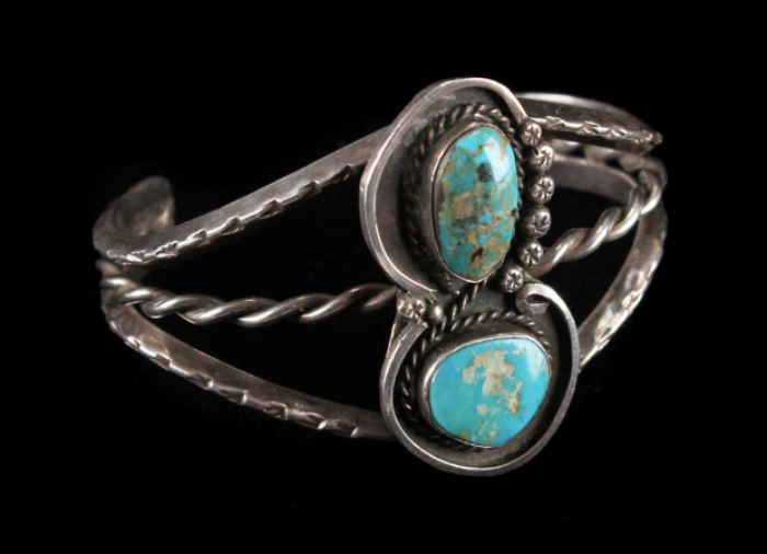 Description: Unmarked Navajo bangle cuff with inset turquoise. 
Condition: Excellent 
Width: 2 1/2 inches. 
Height: 1 3/4 inches. 
Weight: 2 ounces. 
Circa: 1960 
Low Estimate: 100 
High Estimate: 150 