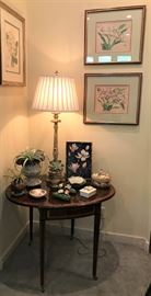 Drop leaf marquetry inlaid table with brass feet, vintage prints