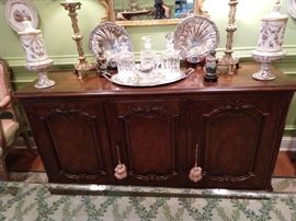 Vintage Baker French sideboard, with silverware drawers, pair of French porcelain lidded urns, pair of vintage brass candlestick lamps, pair of cloisonne vases on stands, pair of English silverplated shell servers, trio of crystal decanters on silverplated tray.