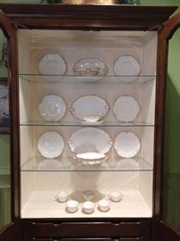 French display cabinet with a few pieces of the vintage Theodore Haviland French Limoges 95-piece china set, ca. 1903