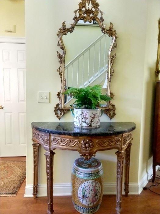 Medium, hand carved antique French gilt wood wall mirror, with one of a pair of antique gilt wood demilune tables, with green marble top.