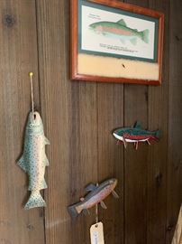 Three carved fish decoys and a framed print of a rainbow trout