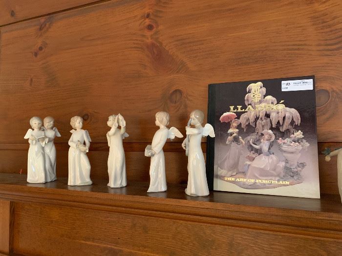 Five LLadro angel figures together with a book