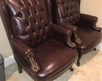 TWO BROWN LEATHER STUDDED ARMCHAIRS
