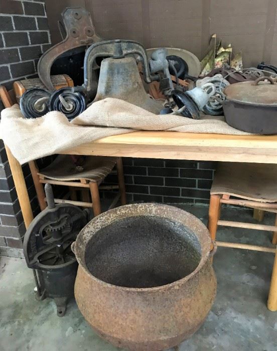 Vintage farm bell, vintage cauldron, vintage Enterprise Mfg sausage press, cast iron skillet, small table w/2 chairs, more