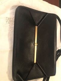 Tory Burch black clutch with brass logo detail. Long strap 2 slip pockets and 1 zipper pocket