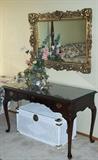 mahogany writing desk; ornate mirror; white wicker trunk (master bedroom)