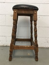 wooden stool with black leather seat.