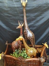 Wooden and leather giraffes in decorative planter  
