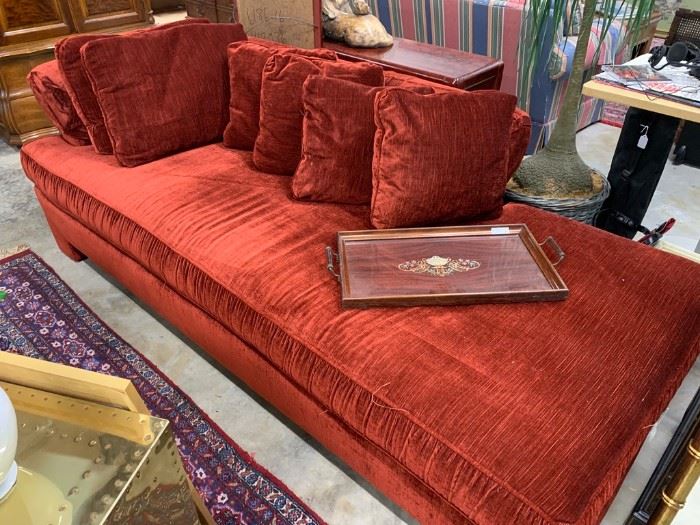 Rusty red chaise lounge with plenty of pillows