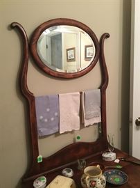 Top of dresser drawer with round mirror.