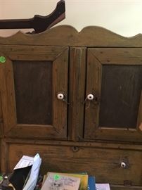 The primitive bread box with doors and shelves at top.