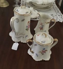 The coffee pot, creamer and sugar dish of the beautiful set of china.