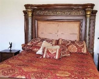 Marble and wood queen bed along with linens and comforters. 