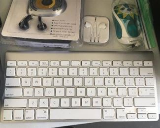 Wireless Apple keyboard, Apple headphone, wireless mouse, handheld radio with earbuds