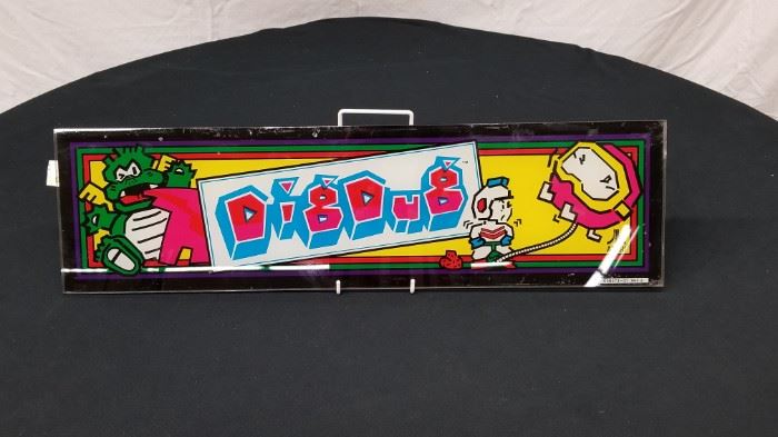 Vintage, Original Atari "Dig Dug" glass arcade game marquee. Marquee measures approximately 23.75" W X 6.5" H. Stand not included. Please see all the additional pinball backglass and arcade game marquees that are offered throughout the auction.
