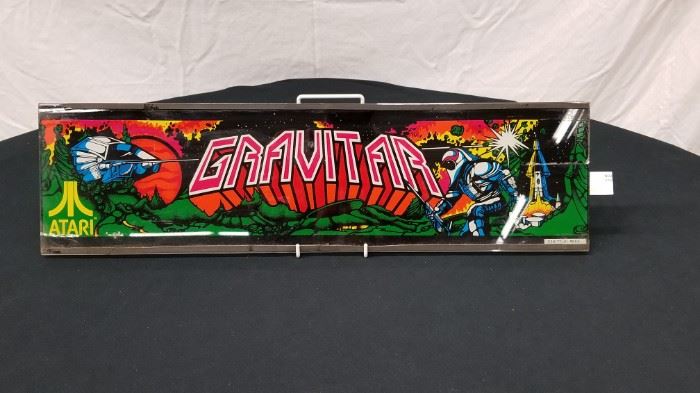 Vintage, Original Atari "Gravitar" glass arcade game marquee. Marquee measures approximately 23.75" W X 6.5" H. Stand not included. Please see all the additional pinball backglass and arcade game marquees that are offered throughout the auction.