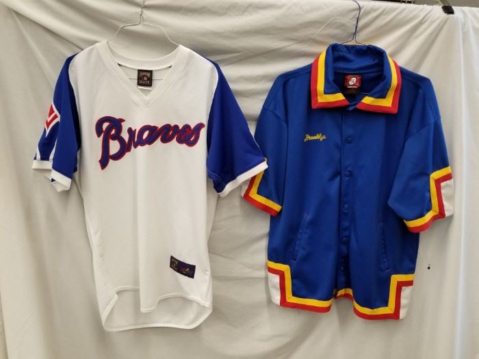 Qty (2) throwback jerseys. Size M Brooklyn Xpress urban wear warm-up basketball jersey. Majestic Cooperstown Collection size L Atlanta Braves Jersey with tag still on. See other lots throughout auction for more baseball memorabilia.