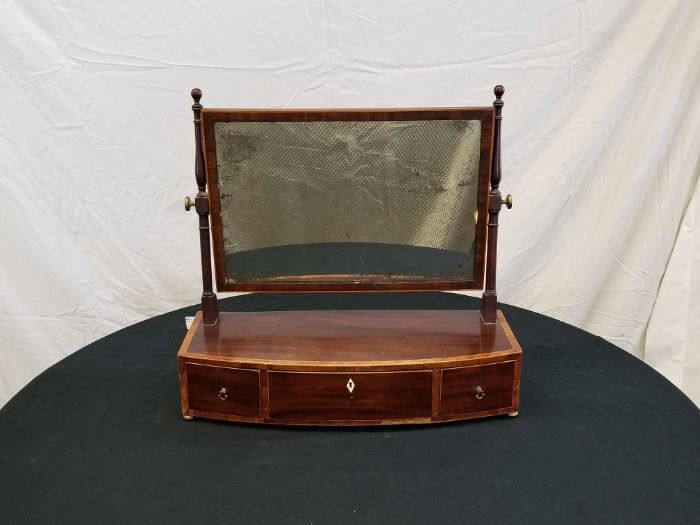 Antique English, Georgian Era Gentleman's Dressing/Shaving Mirror from circa 1810. An exquisite bow-fronted, 3-drawer men's table-top vanity mirror with silvered-back swivel mirror, dovetail drawers and gorgeous inlay around edges of entire piece. Bottom chest of drawers has dimensions of 22.5" W X 9" D X 5" H. Height of bottom part plus mirror is approximately 21.5" tall. This is a very valuable piece, and ones shown on Antiques Roadshow have been valued at $1,000's. This piece has a very moderate reserve. 