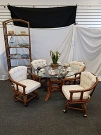 Vintage, 1970's rattan dining room/patio table set from Palm Springs. Thick, glass top table with 4 swivel chairs on rollers with nice, thick, newly upholstered cushions. Would make a great gazebo, pool house, or patio set. Approximate dimensions of table are 48" Diameter by 28.5" height. Heavy duty .5" thick detachable glass tabletop. Qty (4) swivel chairs on wheels. Each chair measures approximately 23" W X 23" D X 17" seat height. X 32" back height. This lot is for the table and chairs only. See matching rattan items in lots 16 and 110. Table decorations NOT included. Please bring help for removal, as the glass top is quite heavy