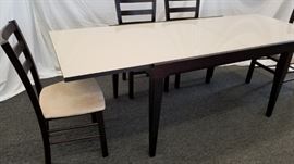 Calligaris, Italian made, Espresso colored, Extendable Dining Room Table with 6 chairs and "self-storing" leaf. This gorgeous, modern design, Calligaris dining table was made in Italy and has a glass surface with a built in "leaf" that slides out from underneath the tabletop. The top slides over and the "leaf" slides up from underneath, extending the 51.25" W table to a 90.5" W table. SEE PICTURES OF HOW IT WORKS!  Super cool! Table is heavy due to leaf being constructed into table. Table measures 51.25" W X 35.5" D X 30" H. Dimensions of table when extended are 90.5" W X 35.5" D X 30" H. Each chair has suede-like fabric seats and measures approximately 18" W X 16" D X 18" H at seat. X 36.5" H at back. Please bring proper help to remove.