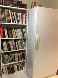 Bookcase full of cookbooks!  Upright freezer.