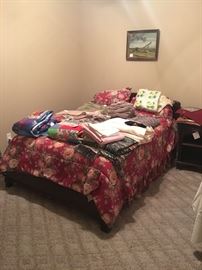 Bed with matching dresser and nightstand and lots of linens