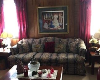 Sofa with numbered and signed print on wall and coffee table with matching end tables