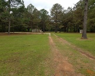 Drive through to the back of the property to building (on left) and well house on right.