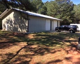 Like-New 40' x 60' Metal Building with (2) Overhead doors, side entry door and concrete floor.  Property also has concrete pad for motor home with electric and water well.