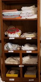 Many sizes of handmade, crocheted doilies, runners, and tablecloths