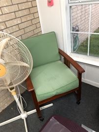 One of the chairs in the patio set and stand fan