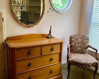 Pine chest, oval gold framed mirror, upholstered arm chair.