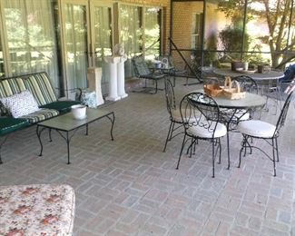 Large screened porch with outdoor furniture and hammock stand