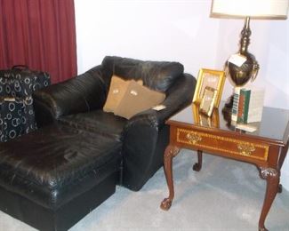 Large over stuffed black leather chair and ottoman with side table